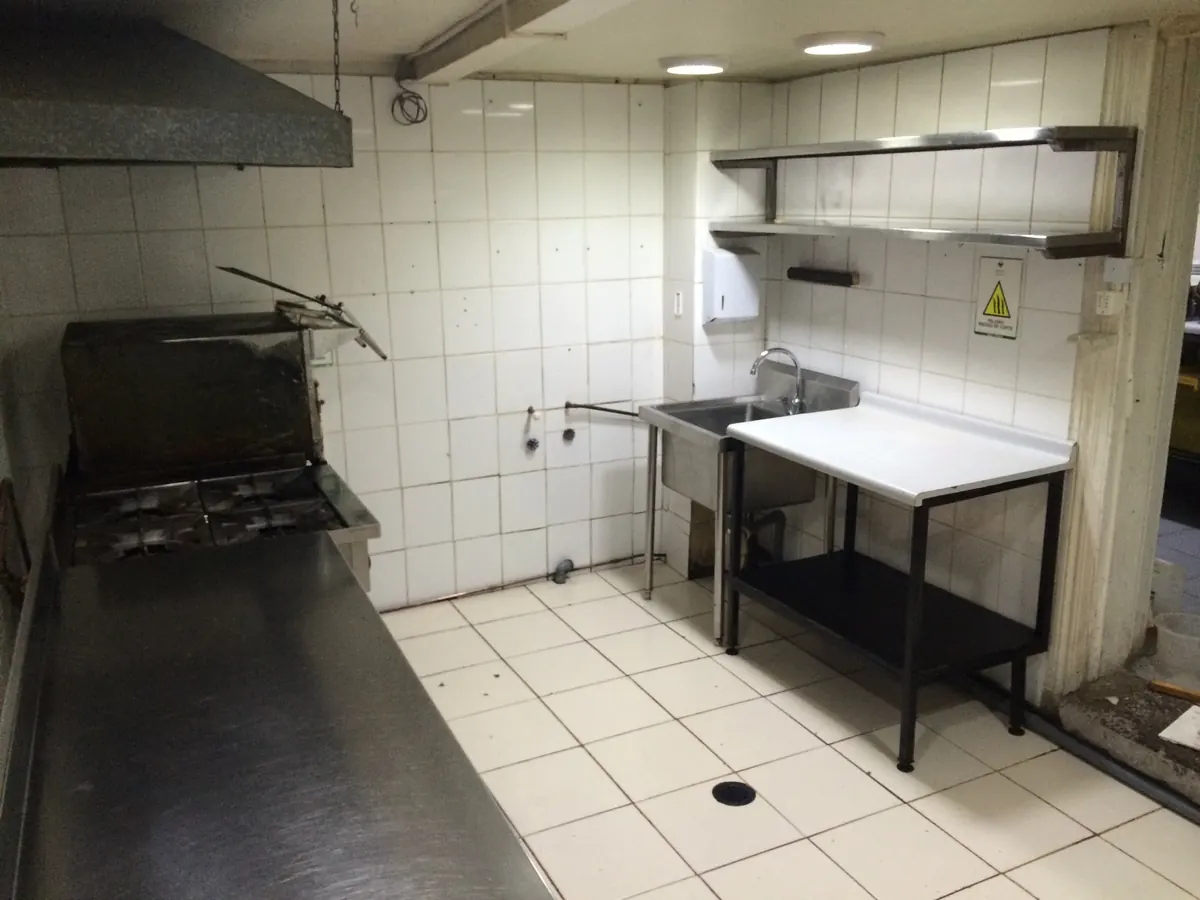 Cocina industrial con campana y ductos desengrasados